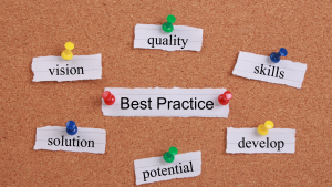 Pinned notes with words like best practice, quality, vision, and solution on a corkboard.